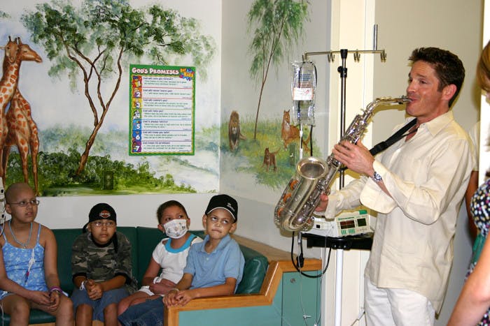 Dave Koz playing sax for hospitalized kids